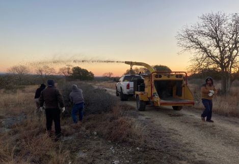 Our crew hand clearing and chipping undesirable brush just after daybreak on a cold winter morning.